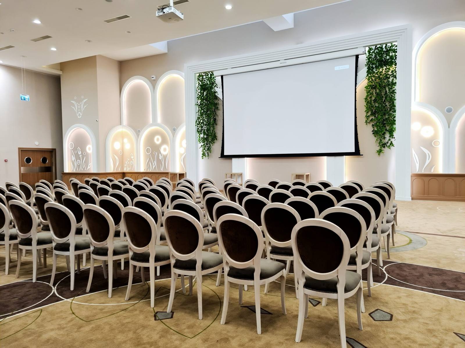 Hall arranged for a conference, with a projection screen