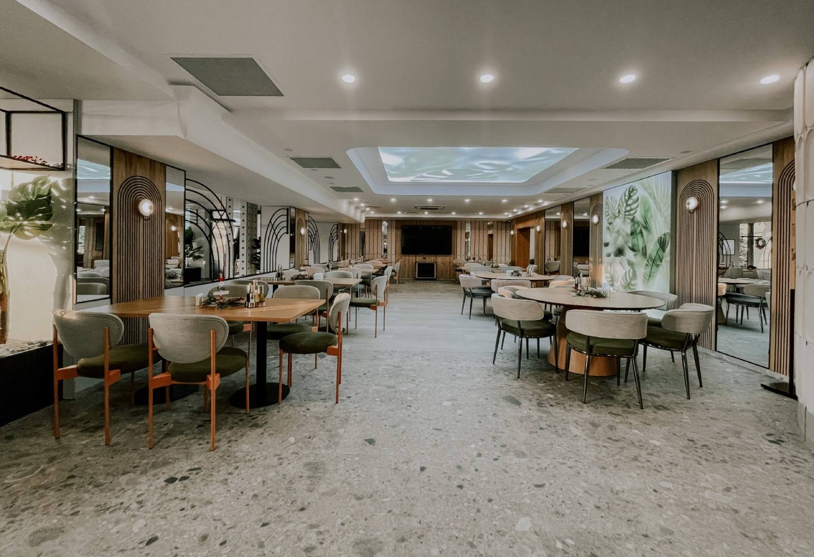 The refurbished dining room — green sofas, arches and natural light