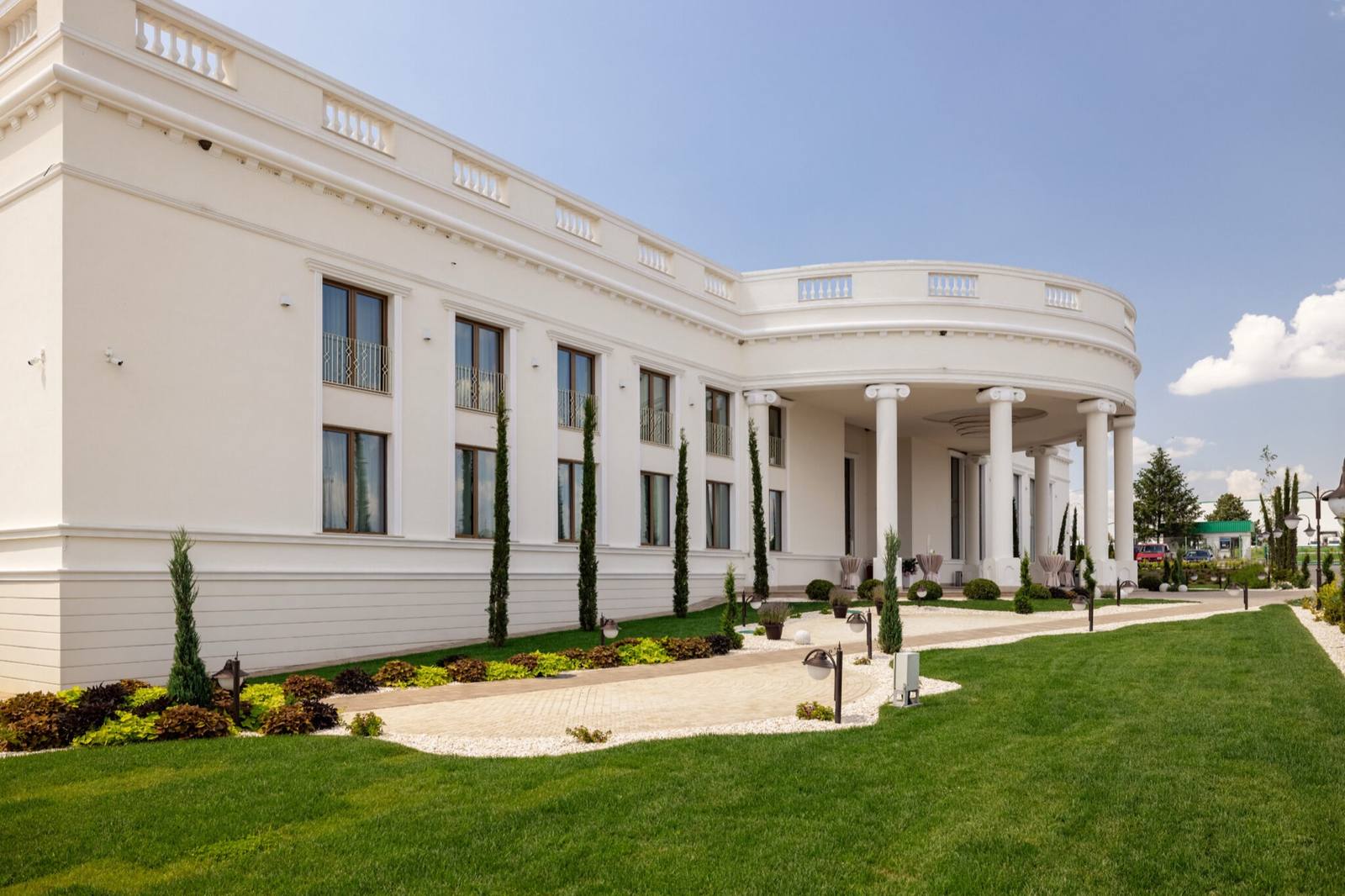 The white facade of the Coroana Events estate, with colonnades